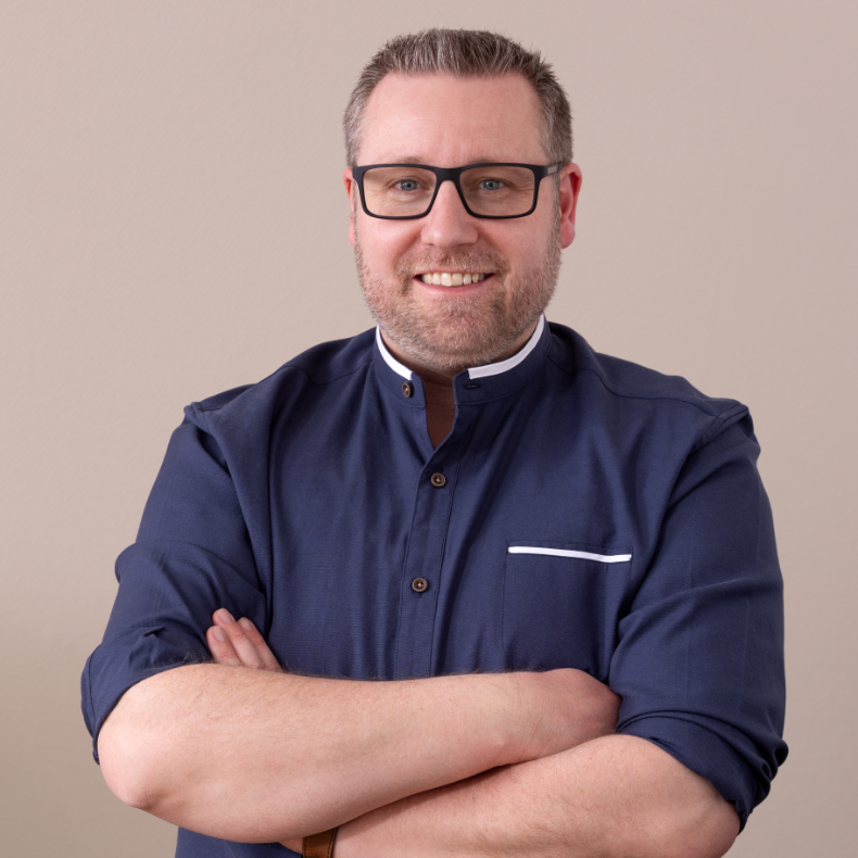 Porträt eines lächelnden Teammitglieds der AFMO eG im grauen Sakko