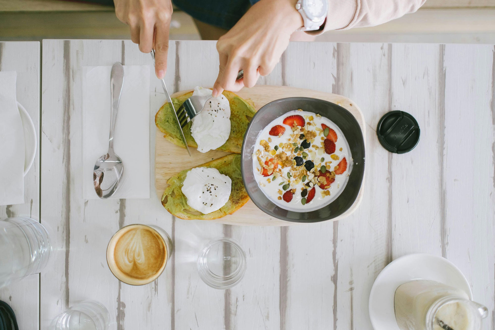 Frühstück mit Joghurt, Müsli und Erdbeeren auf einem Tisch