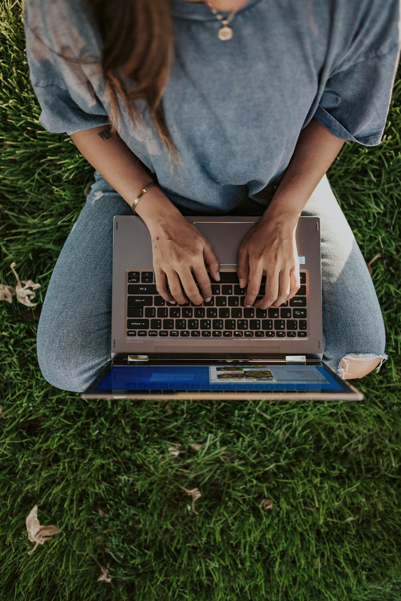 Person arbeitet mit einem Laptop im Freien