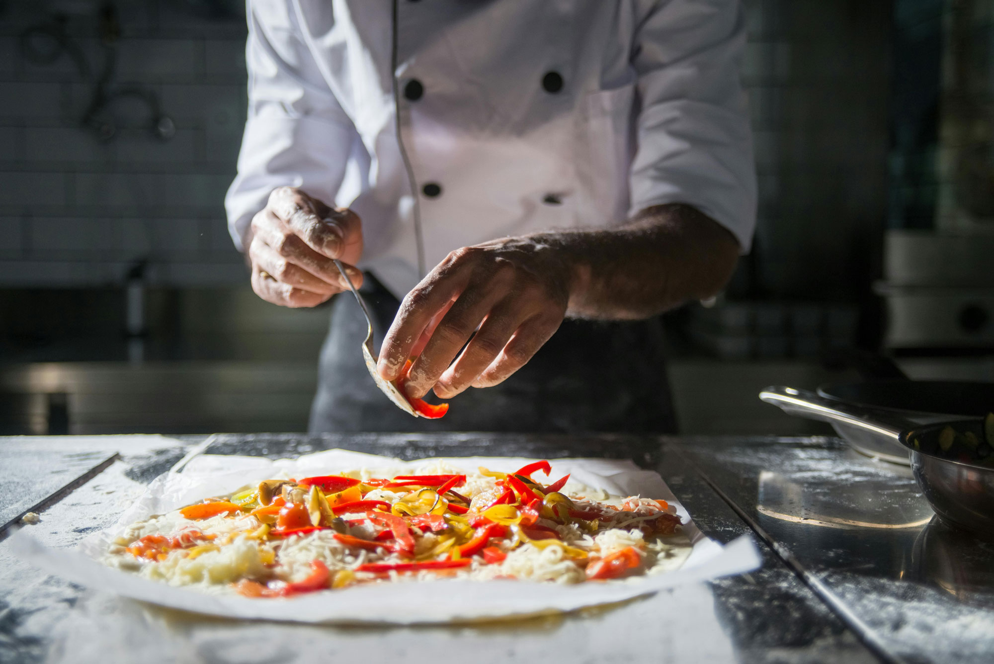 Pizzabäcker bei der Zubereitung einer Pizza